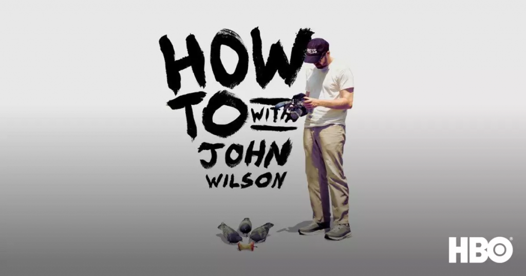 Promotional image for the HBO series How To with John Wilson. Shows a man wearing a white T-shirt, beige pants, and a cap holding a camera while looking down. Three pigeons stand on the ground in front of him, and the series title “How To with John Wilson” is written in bold, black hand-drawn letters beside him, with the HBO logo in the corner.