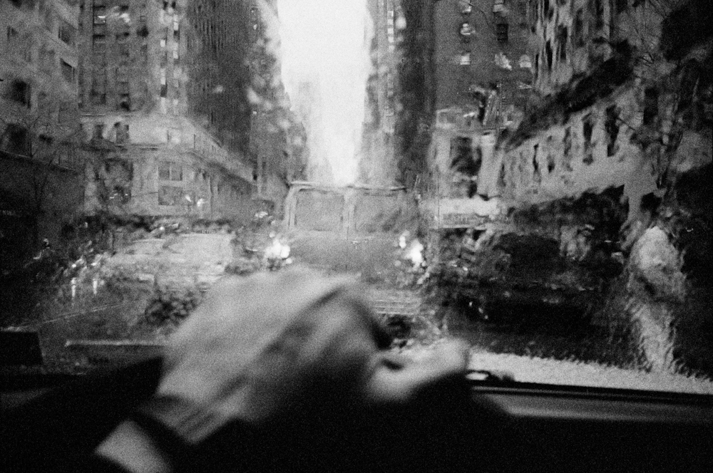 Image from the drivers perspective, driving down a rainy street in New York